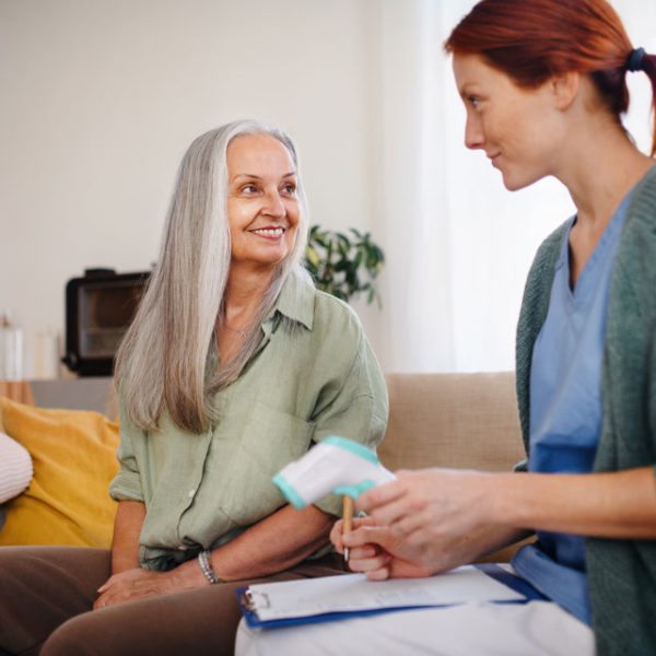 Nurse cosulting with senior woman her health condition at her home.