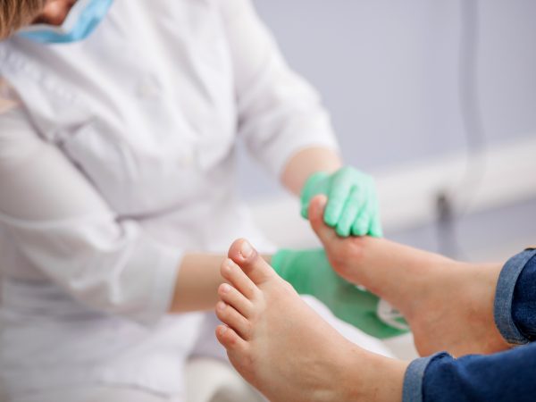 doctor, the podiatrist examines the foot